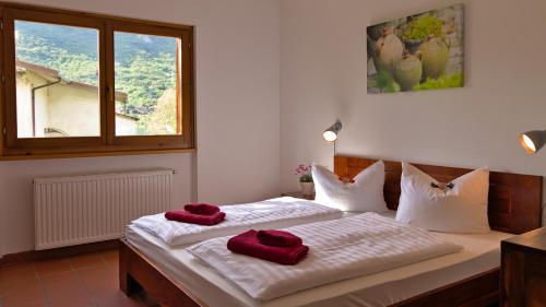 ein Schlafzimmer mit 2 Betten und roten Handtüchern darauf in der Unterkunft Case Vacanze Crone in Crone