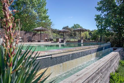 - une piscine avec des parasols dans l'établissement Gîtes du Lamalou, à Notre-Dame-de-Londres