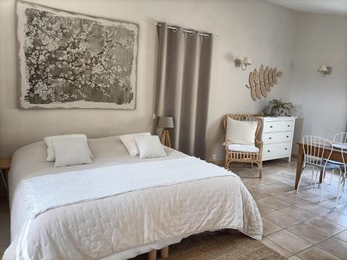1 dormitorio con 1 cama, mesa y sillas en La Ferme Les Eybrachas, en Réauville
