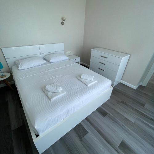 a bedroom with a white bed and a dresser at Real Beach Tower in Batumi