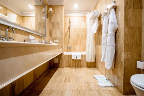 ein Badezimmer mit einer Badewanne, einem Waschbecken und einem WC in der Unterkunft Cosmonaut in Qaraghandy