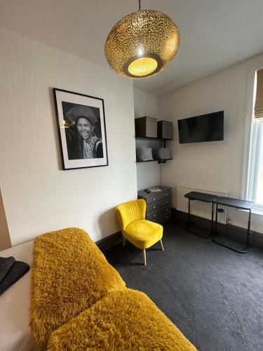 a living room with a couch and a table at Green Corner Villa - Cosy Luxury in Central Torquay with Free Parking & EV in Torquay