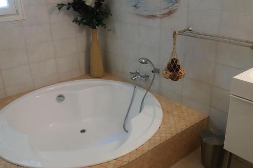 une baignoire avec un robinet dans une salle de bain dans l'établissement Villa de charme la Vinadière avec piscine privée et chauffée, à Voutezac