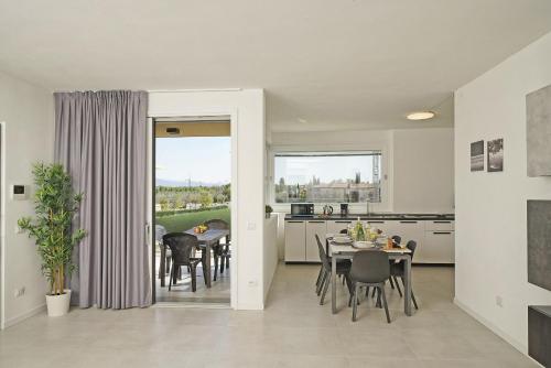 uma cozinha e sala de jantar com mesa e cadeiras em Katya Resort Apartments by Wonderful Italy em Desenzano del Garda
