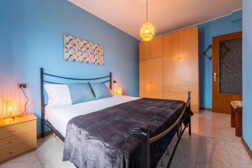 een slaapkamer met een bed en een blauwe muur bij Un Balcone sul Lago by Wonderful Italy in Montemezzo