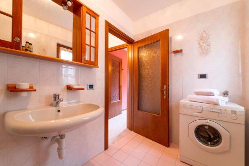 een badkamer met een wastafel en een wasmachine bij Un Balcone sul Lago by Wonderful Italy in Montemezzo
