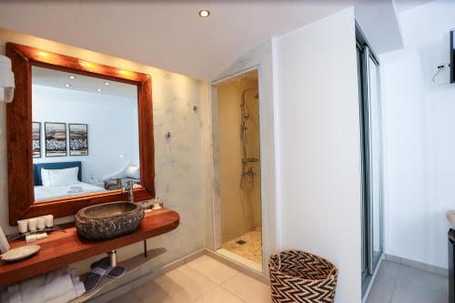 a bathroom with a sink and a mirror at Ibiscus Boutique in Mýkonos City