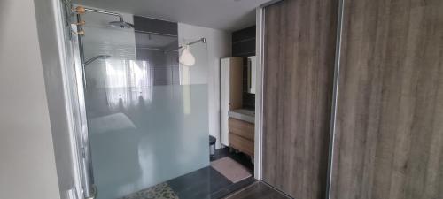 a shower with a glass door in a bathroom at Chambre n°2 dans logement - Chez Ana in Changé