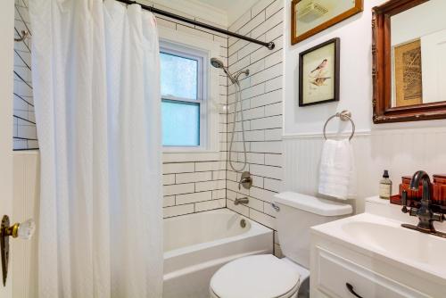 a white bathroom with a toilet and a sink at Whimsical Cottage Near Springfield Art Museum! in Springfield