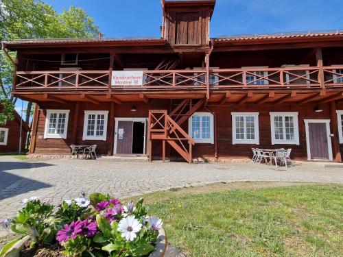 un grand bâtiment en bois avec des fleurs devant lui dans l'établissement Vandrarhemmet Färgaren, à Eksjö