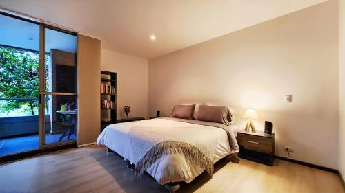 1 dormitorio con cama y ventana grande en Apartment in countryside with hotel services, en Rionegro