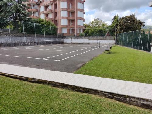 una pista de tenis frente a un edificio en Duplex en Ris, en Noja