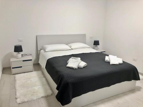 a white bedroom with a large bed with two pillows at Sapphire Penthouse in Tropea