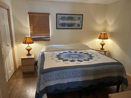 a bedroom with a bed with two lamps on tables at Creekside Downtown Vacation Suites, Only Adults 25 or older in Buffalo