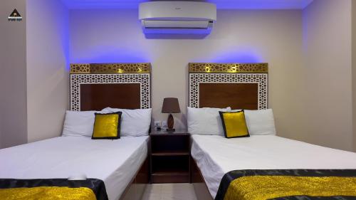 two beds with yellow pillows in a room at Pyramids Height Hotel & Pyramids Master Scene Rooftop in Cairo