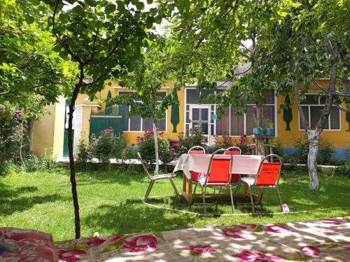 a table and chairs in the yard of a house at Rakaposhi Amin Hotel & Restaurant Pissan Hunza Nagar Gilgit Baltistan in Gilgit