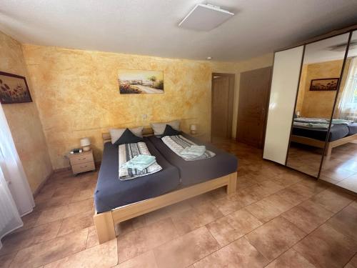 - une chambre avec un lit et un grand miroir dans l'établissement Pension LeLiLa Rust - ex Gästehaus Milella, à Rust