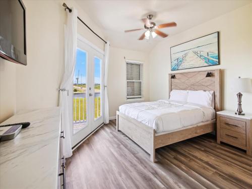 a bedroom with a bed and a ceiling fan at Oceanside Paradise in Galveston