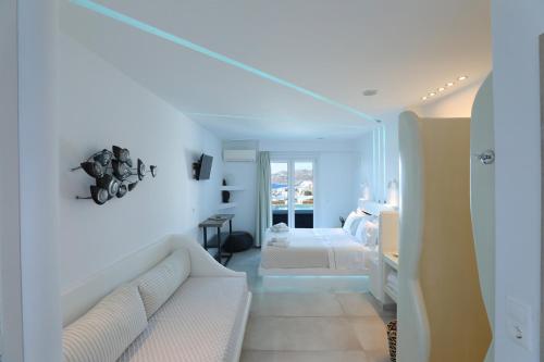 a white living room with a couch and a bedroom at Ibiscus Boutique in Mýkonos City