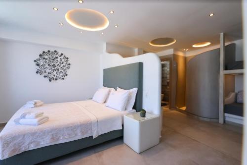a bedroom with a large bed with white sheets at Ibiscus Boutique in Mýkonos City