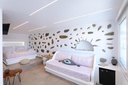 a bedroom with a couch and a wall with seashells at Ibiscus Boutique in Mýkonos City