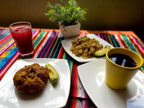 una mesa con dos platos de comida y una taza de café en La Estación Hostal, en Quito