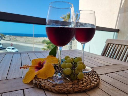 dos copas de vino y uvas en una mesa en Ola Cotillo! Ver y Sentir el Mar desde casa en Cotillo
