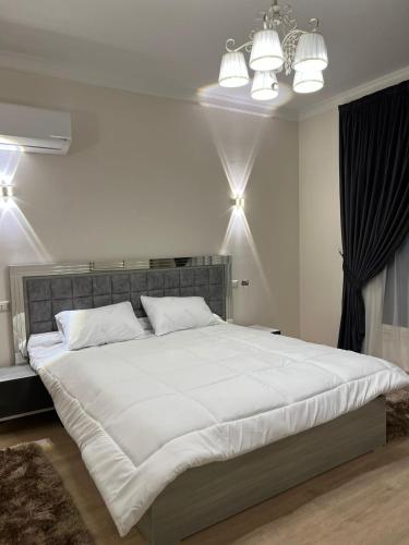 a bedroom with a large white bed with lights at Elite Residence in Sheikh Zayed