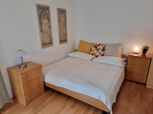 sypialnia z łóżkiem, 2 komodami i lampką w obiekcie Maisonette Wohnung Wörthersee w mieście Sekirn