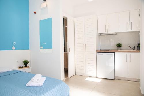 een slaapkamer met een bed en een keuken met witte kasten bij Central Apartments in Stavros