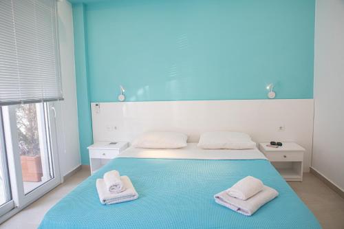 a blue bedroom with a bed with towels on it at Central Apartments in Stavros