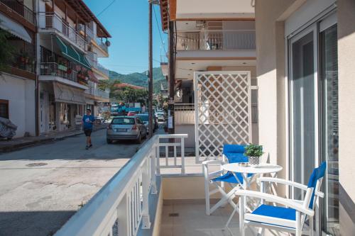 einen Balkon mit einem Tisch und Stühlen auf einer Straße in der Unterkunft Central Apartments in Stavros