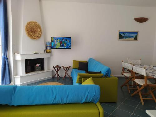 een woonkamer met een bank en stoelen en een open haard bij Casa blu in Conca Specchiulla