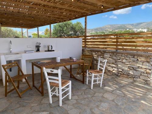 a patio with a table and chairs and a stone wall at Secret Garden - Apartment with jacuzzi in Kampos Paros
