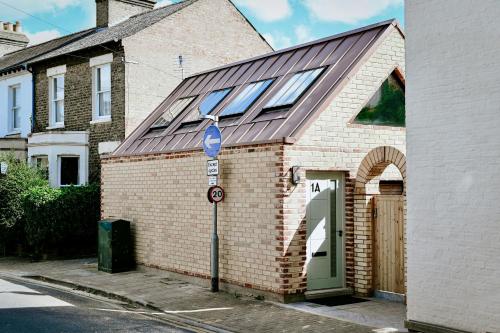a brick house with a solar roof on a street at Emery Street Lodge in Cambridge