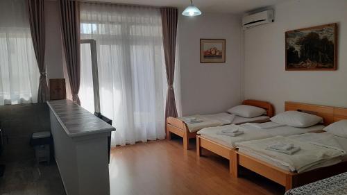 ein Hotelzimmer mit 2 Betten und einem Tisch in der Unterkunft Apartment Jasna in Mostar