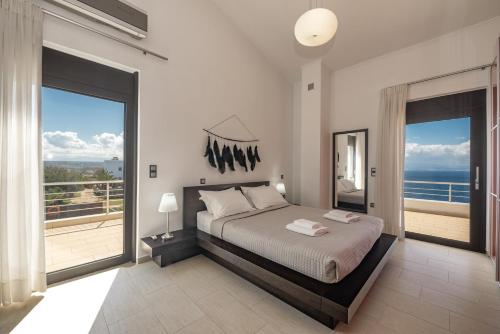 sypialnia z łóżkiem i widokiem na ocean w obiekcie Villa del Mare, built on the edge of the sea w mieście Chorafakia