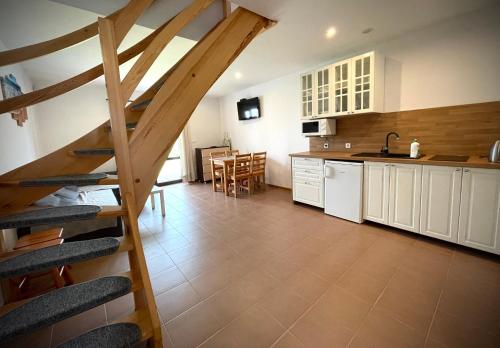 a kitchen with a staircase leading up to a loft at Domki Letniskowe Ratownik in Sarbinowo