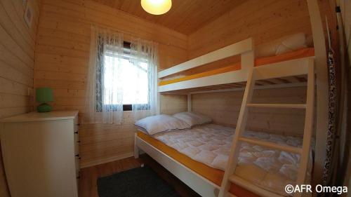 Domki Letniskowe Ratownik في ساربينوفو: غرفة نوم مع سريرين بطابقين في كابينة