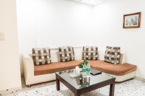 a living room with a couch and a coffee table at Asian Suites IFFCO Metro Station Gurugram in Gurgaon
