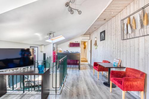 un salon avec des chaises rouges et une table dans l'établissement Superbe Appartement Vue sur la Confluence LOIRE, à Bouchemaine