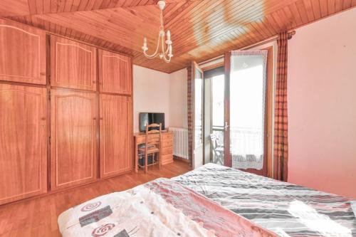 a bedroom with a bed and wooden cabinets and a window at Appartement de 2 chambres avec balcon amenage et wifi a Courchevel a 6 km des pistes in La Perrière
