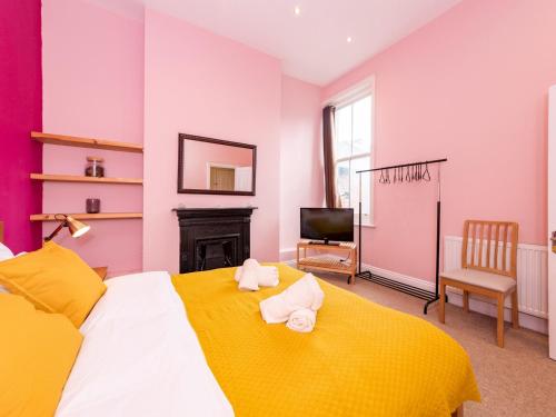 ein Schlafzimmer mit einem gelben Bett mit Handtüchern darauf in der Unterkunft Pass the Keys Newly Renovated Stylish 2BR Flat in Town Centre in Reading