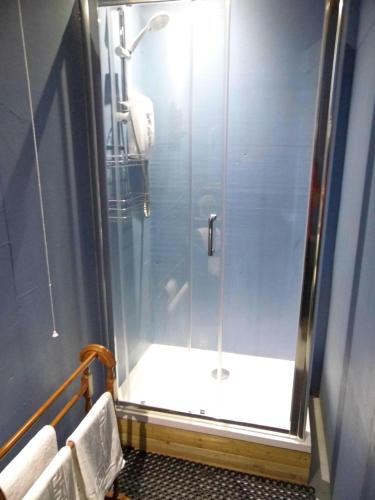 a shower with a glass door in a bathroom at The Yurt in Cornish woods a Glamping experience in Penzance