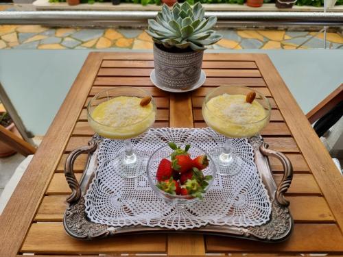 a table with two glasses and a bowl of fruit at Double17 Apartaments in Gjirokastër
