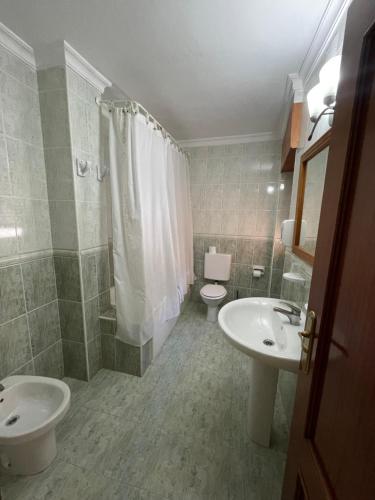 La salle de bains est pourvue de 2 lavabos, de toilettes et d'une douche. dans l'établissement Hotel Restaurante Felipe II, à Ayna