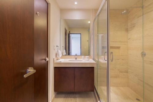 ein Bad mit einem Waschbecken und einer Dusche in der Unterkunft Stylish Condo - Private Plunge Pool - 300Mbps - Rooftop in Playa del Carmen