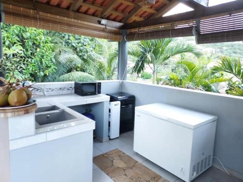 a kitchen with white appliances and a large window at L' authentique in La Trinité