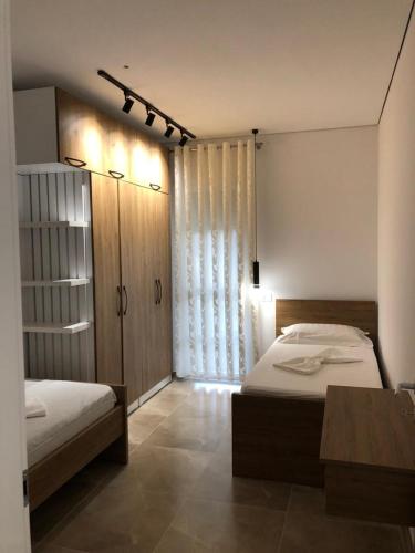 a bedroom with two beds and a table in it at Illyrian Elite Gjiri i Lalezit in Draç