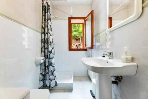 a bathroom with a sink and a toilet and a mirror at Villa Puerto in Sóller